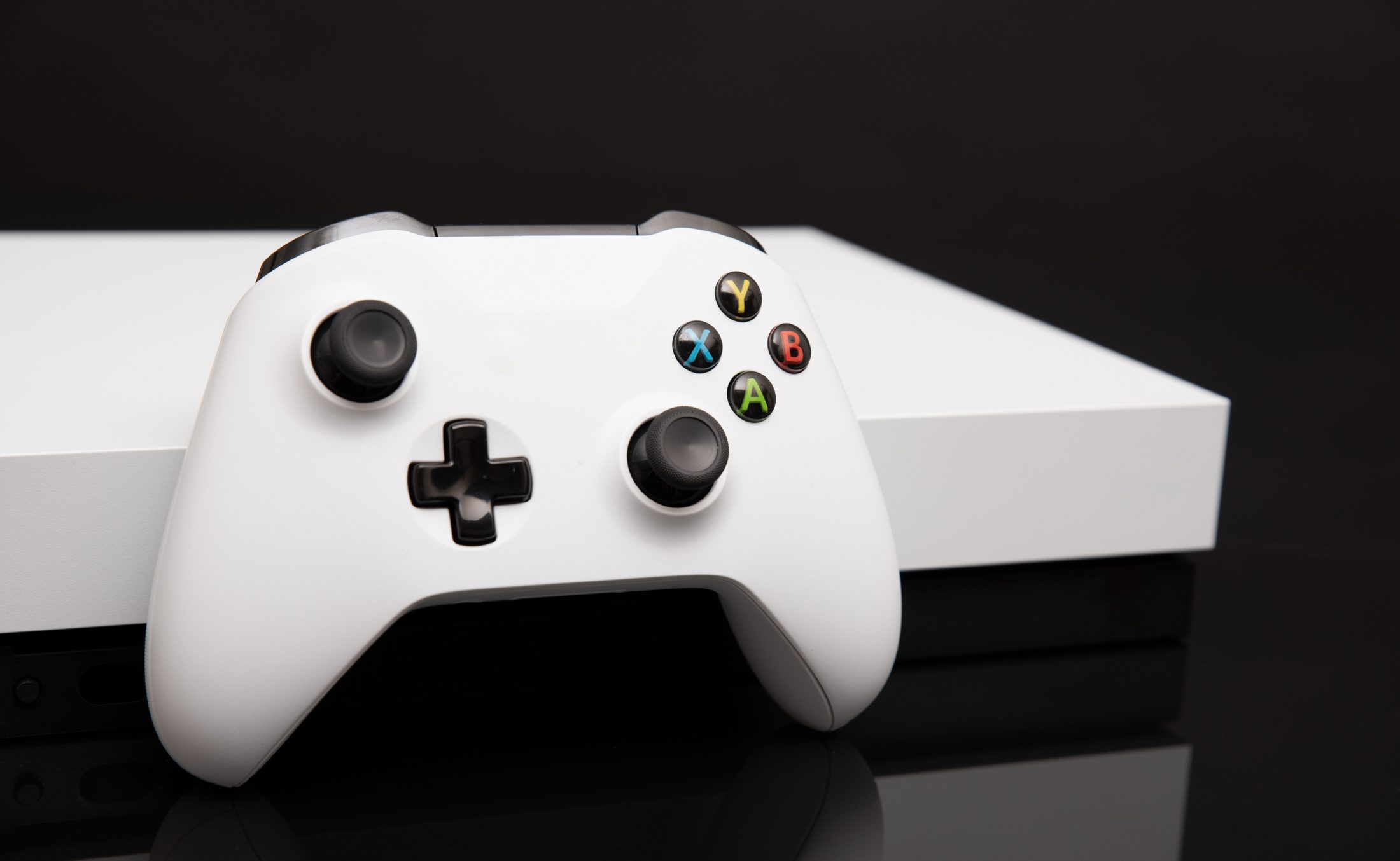 A refurbished white Xbox console and controller on the TRS bench